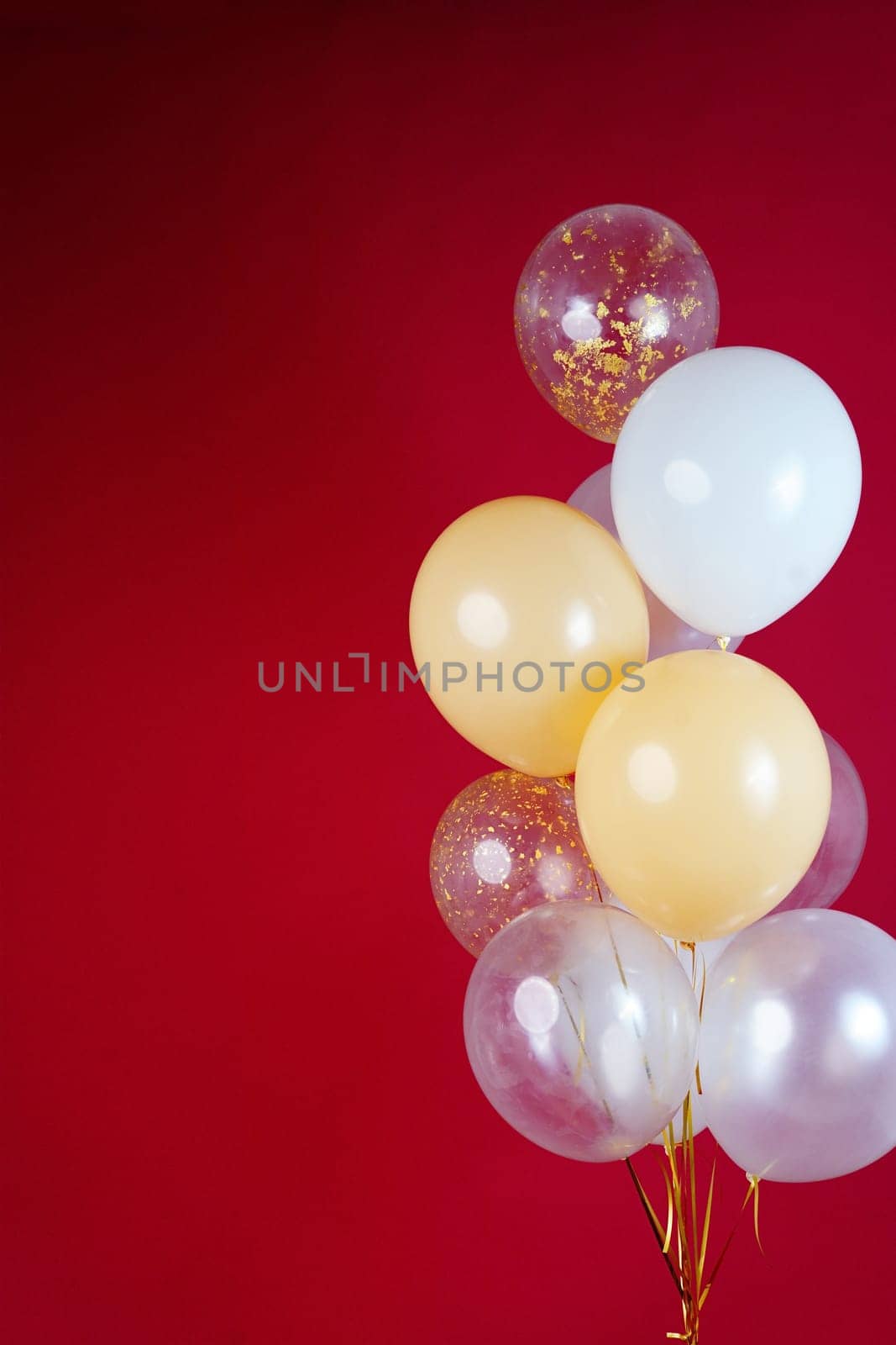 A bunch of light balloons on a red background. Vertical Photo Space for Text. High quality photo