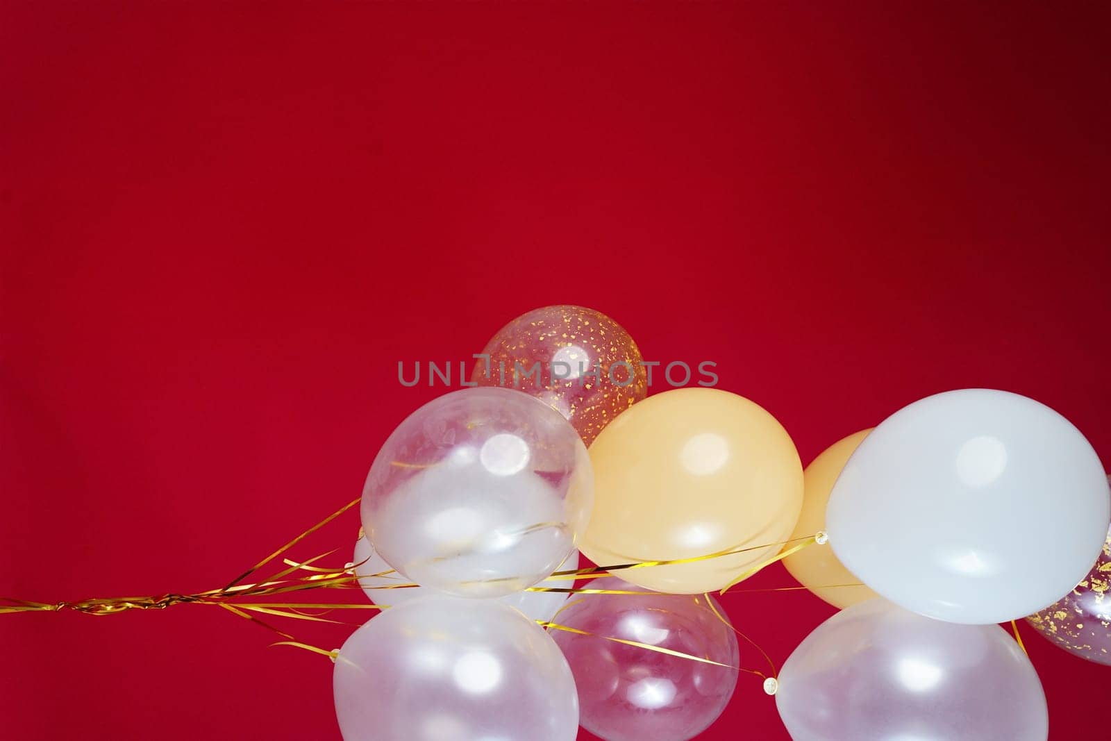 A bunch of light balloons on a red background. Vertical Photo Space for Text. High quality photo