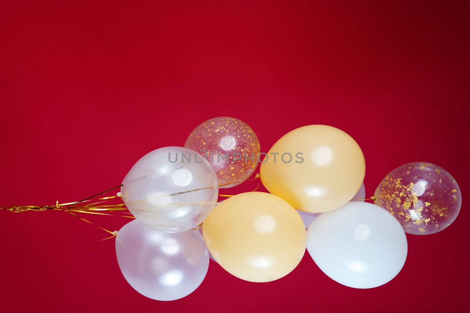 A bunch of light balloons on a red background. Vertical Photo Space for Text by tewolf