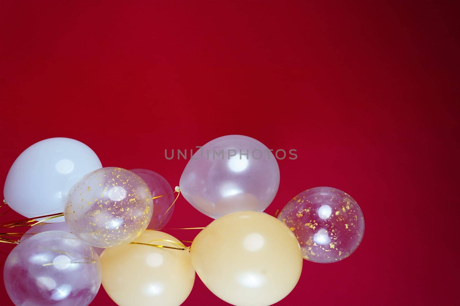 Vertical photo of white and transparent balloons on red burgundy background. Space for text. High quality photo