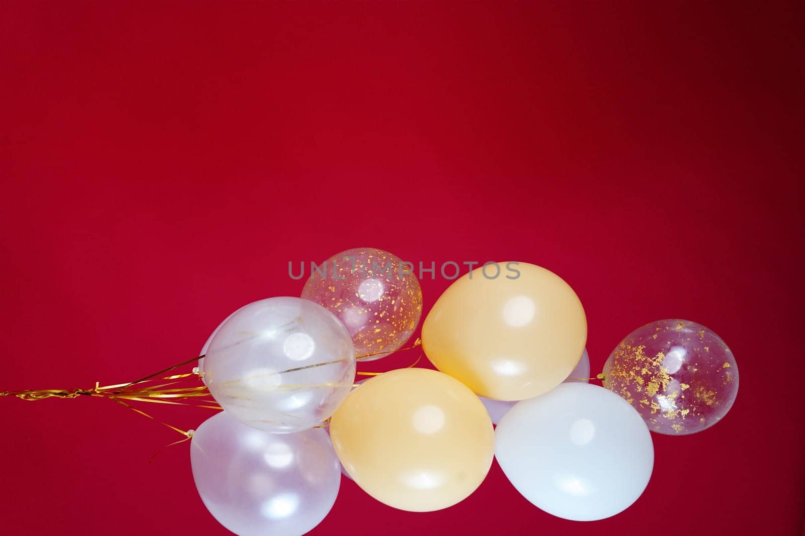 A bunch of light balloons on a red background. Vertical Photo Space for Text. High quality photo