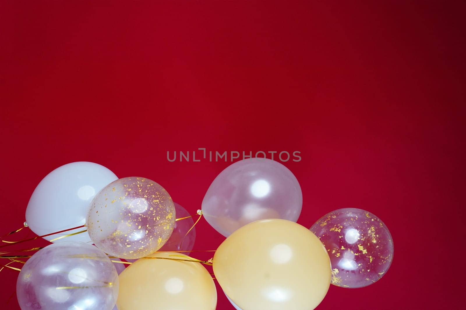 Vertical photo of white and transparent balloons on red burgundy background. Space for text by tewolf