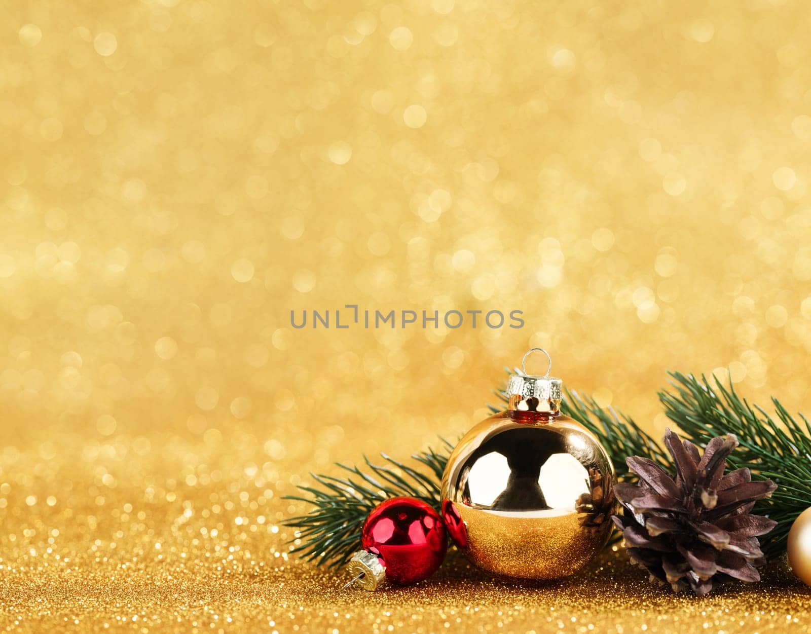 red and gold balls and fir on golden bokeh background