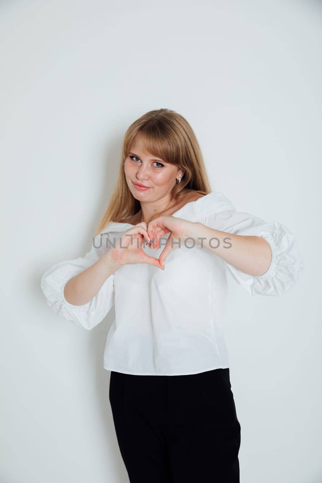 Beautiful young woman showing her heart with her hands by Simakov