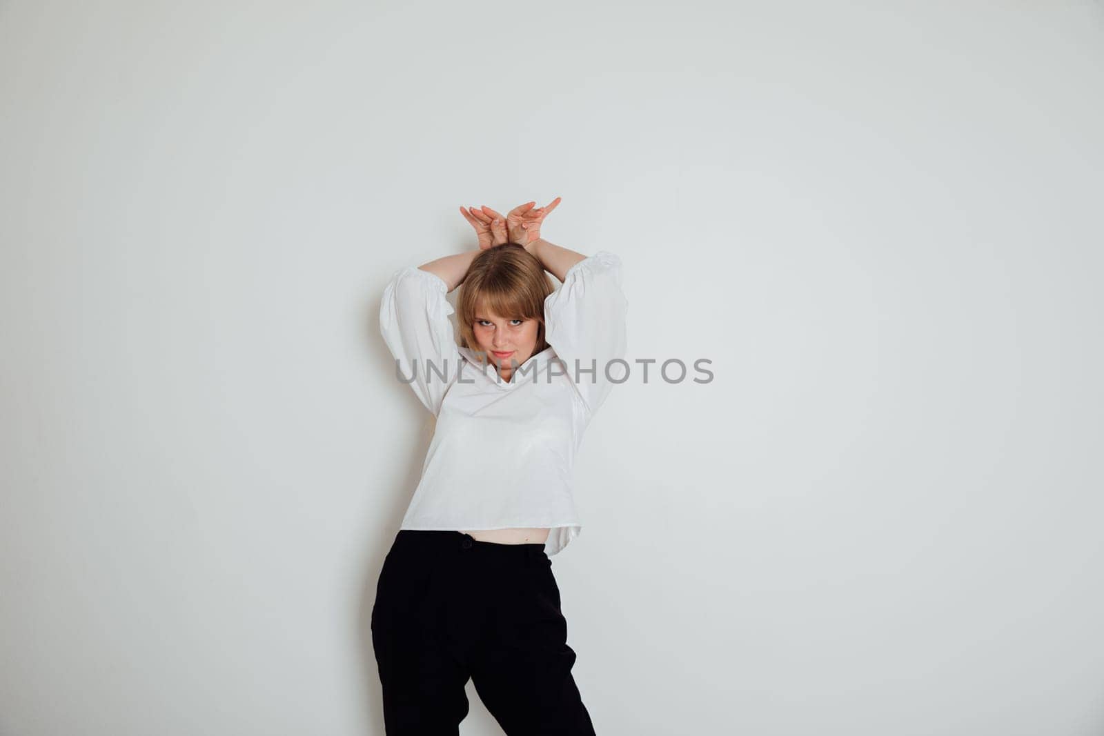 Beautiful young woman showing bunny ears with her hands by Simakov