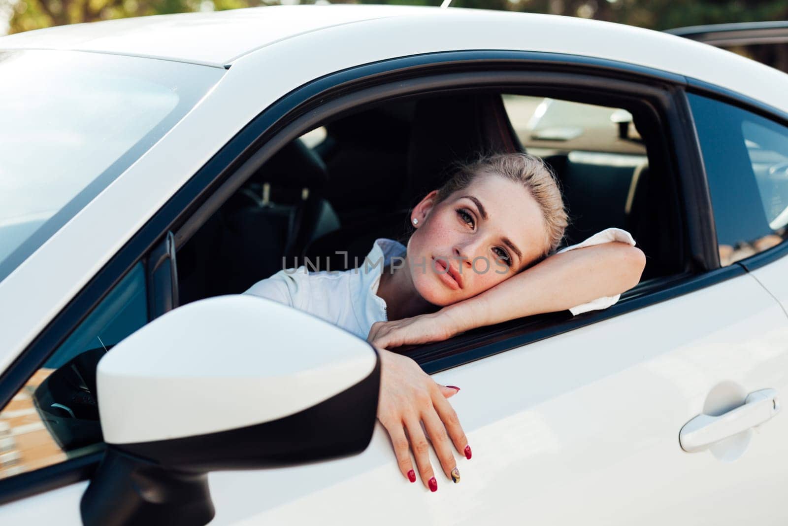 Blonde woman driving a car driver on the road by Simakov