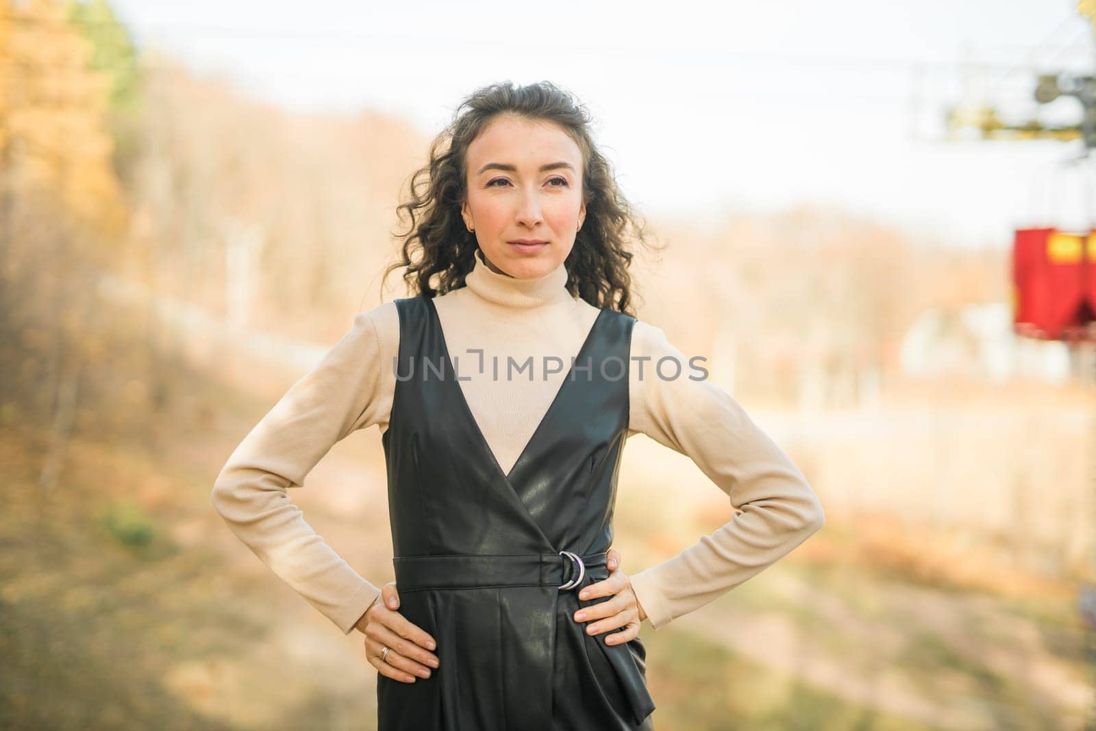 Girl in fall forest. Woman with long curly hair. Beautiful sunlight in the forest. Hair care. Millennial Generation and youth