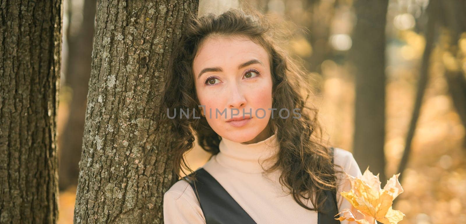 Banner portrait woman walking in autumn park, happy mood and fashion style trend and curly long brown hair copy space. Fall season and pretty female portrait copy space. Millennial generation concept by Satura86