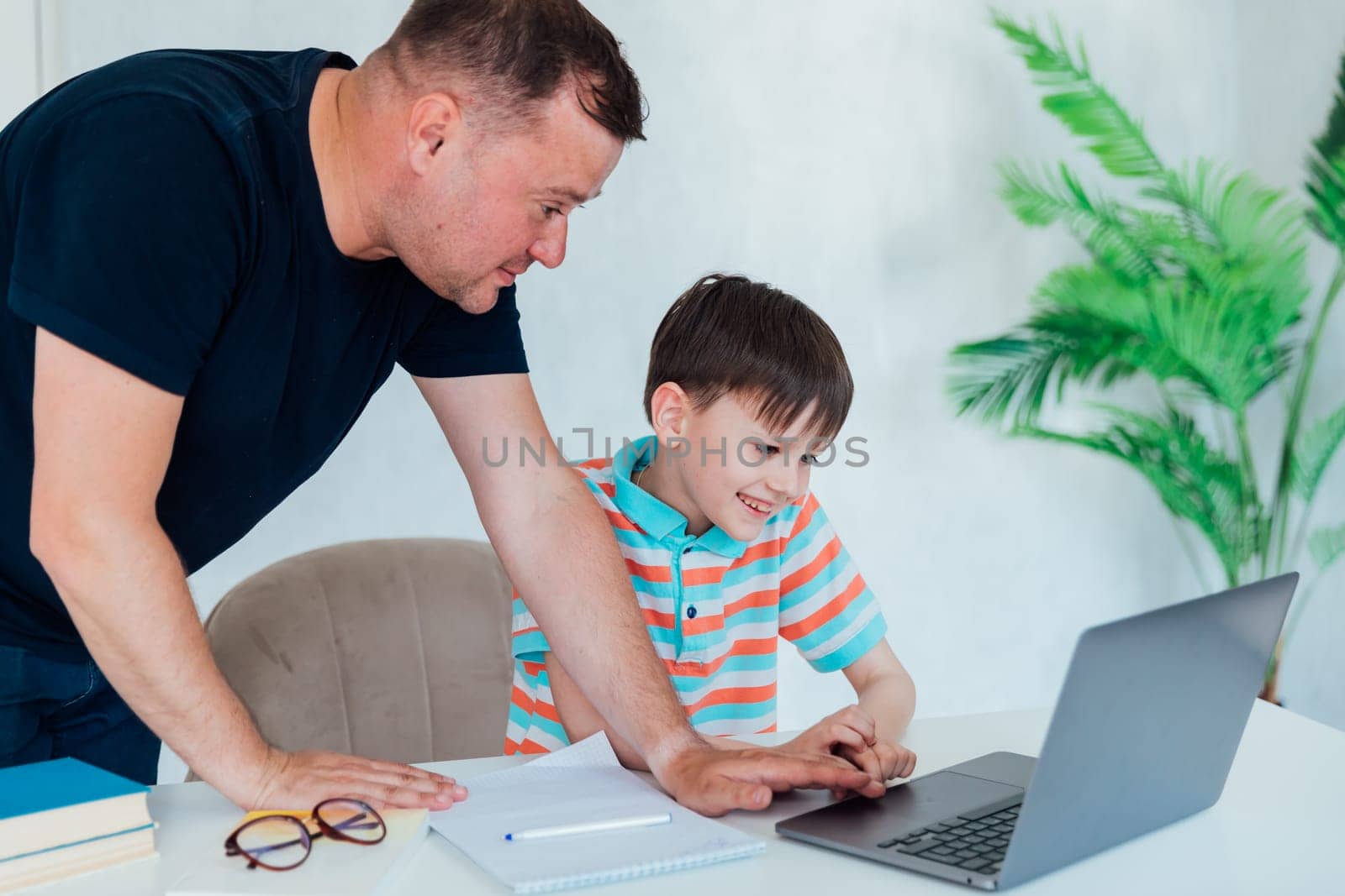 Man helping child studying at computer class