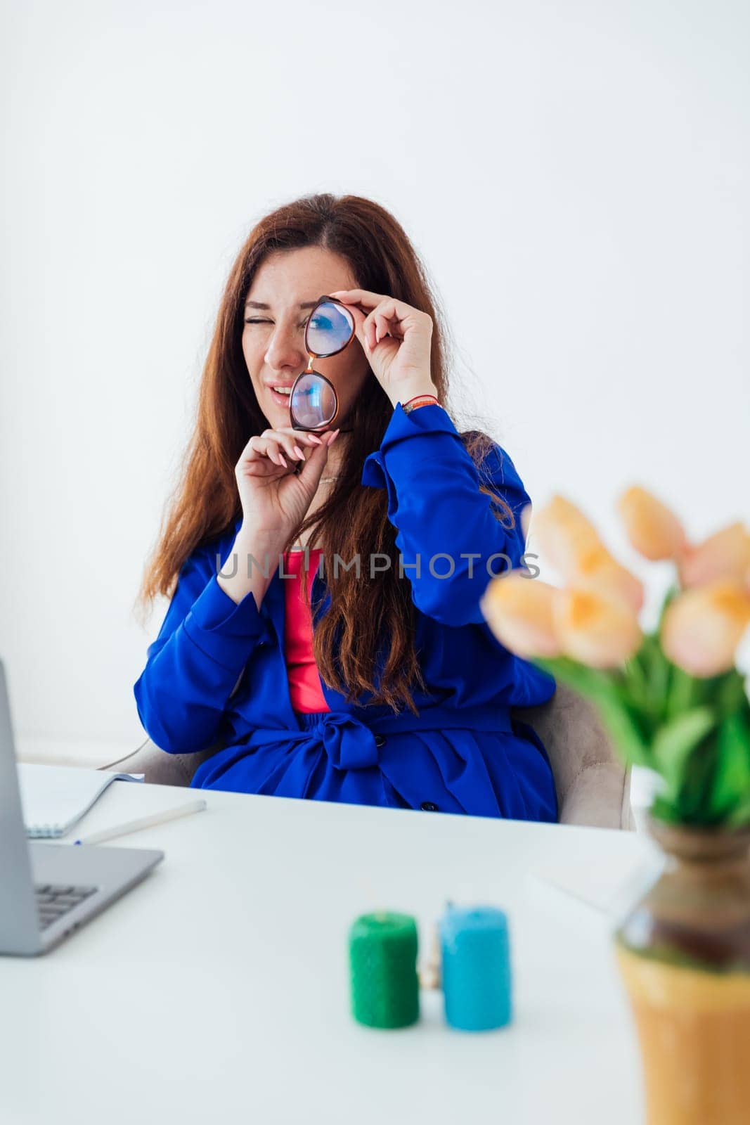 woman looking at glasses and smiling