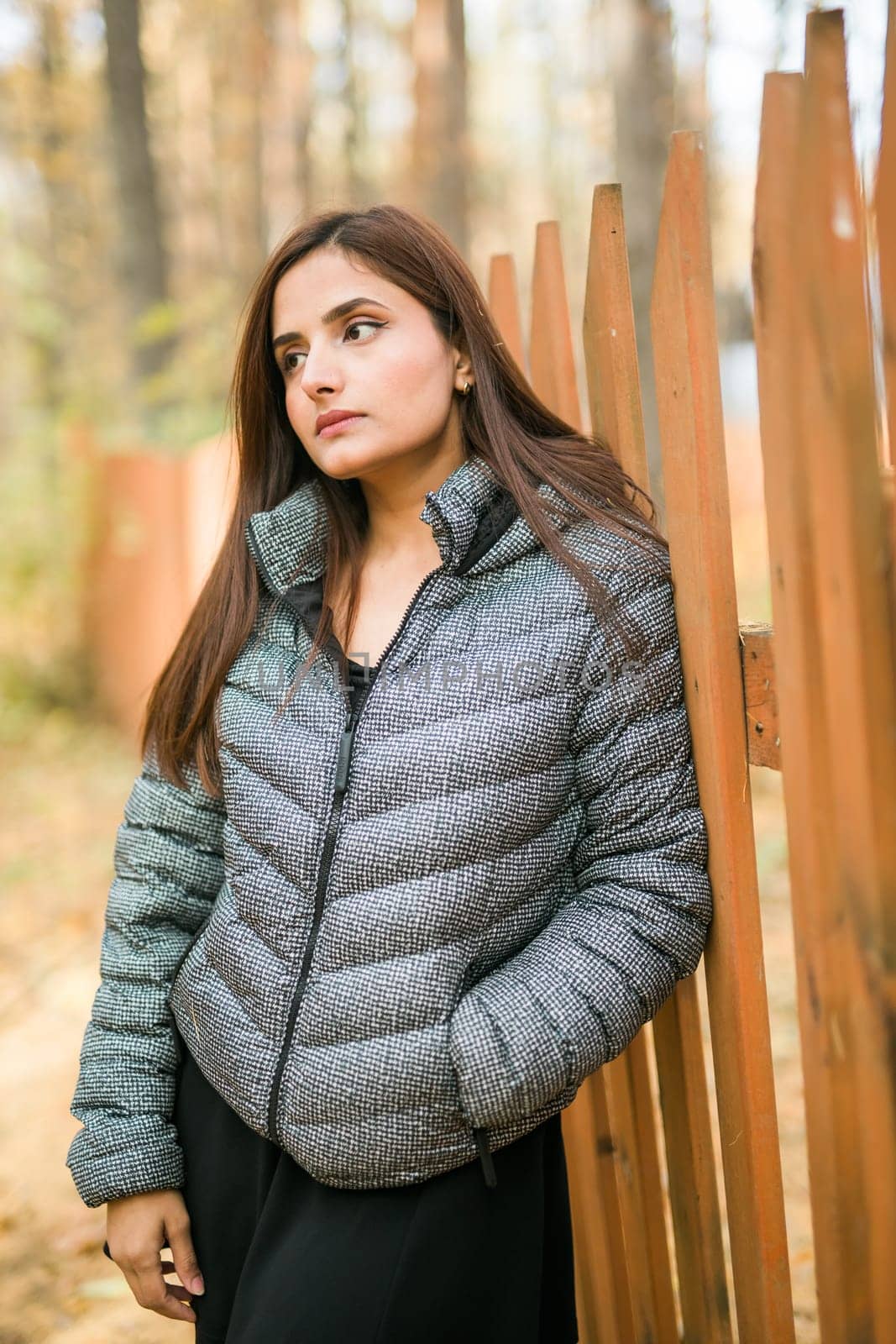 Close up portrait of pretty indian young woman enjoying warm autumn sunny day vacation outdoors. Generation z and gen z concept. Fall Season.