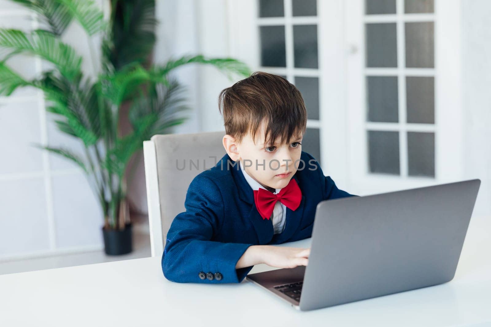 Little boy learns to work on a laptop by Simakov
