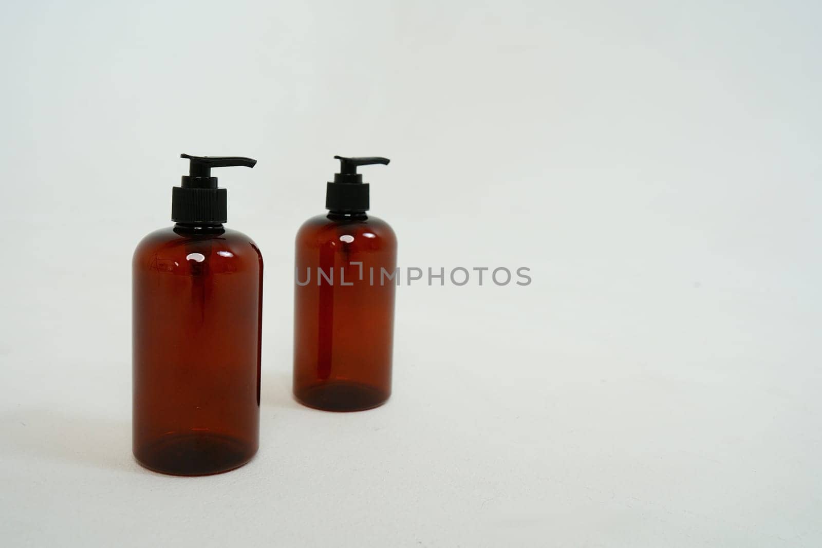 Two dark bottles with soap dispensers on a white background. isolated on white background by tewolf