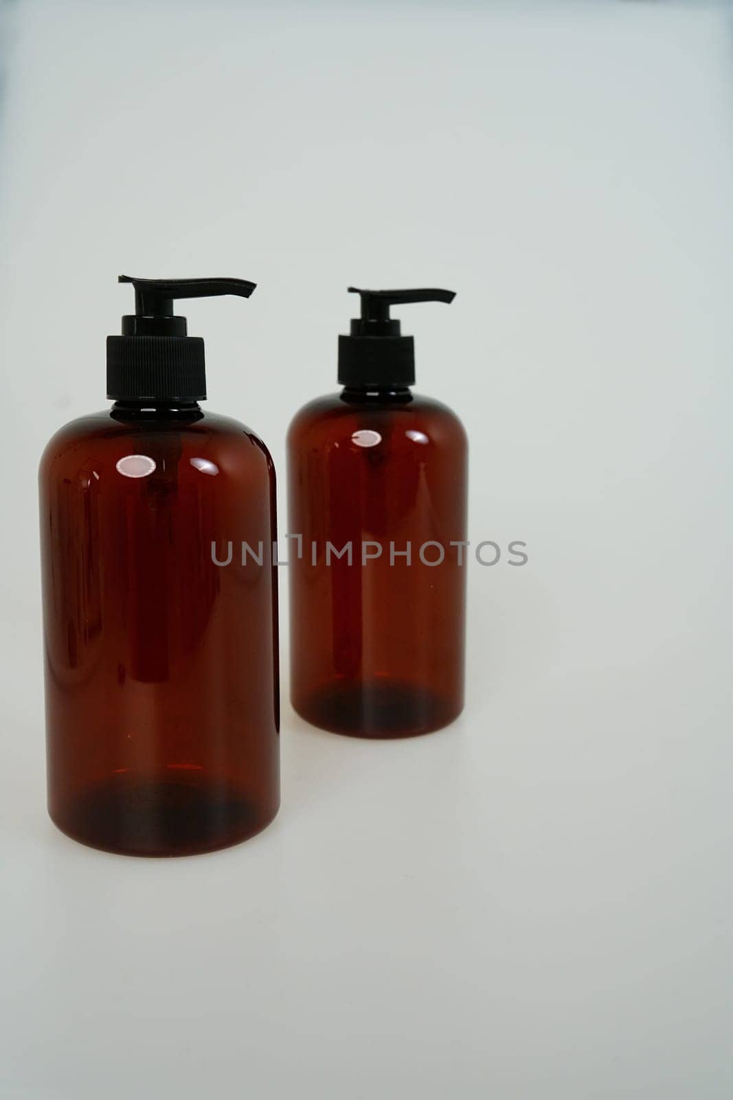 Two dark bottles with soap dispensers on a white background. isolated on white background. High quality photo