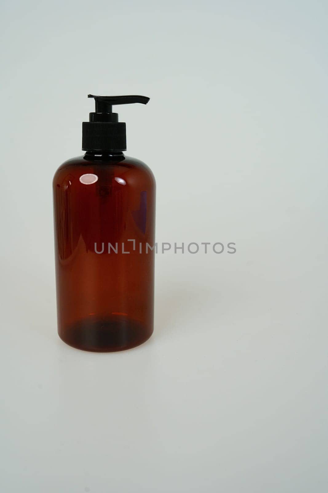 Dark shampoo or soap bottle on light background. space for text. isolated on white background by tewolf