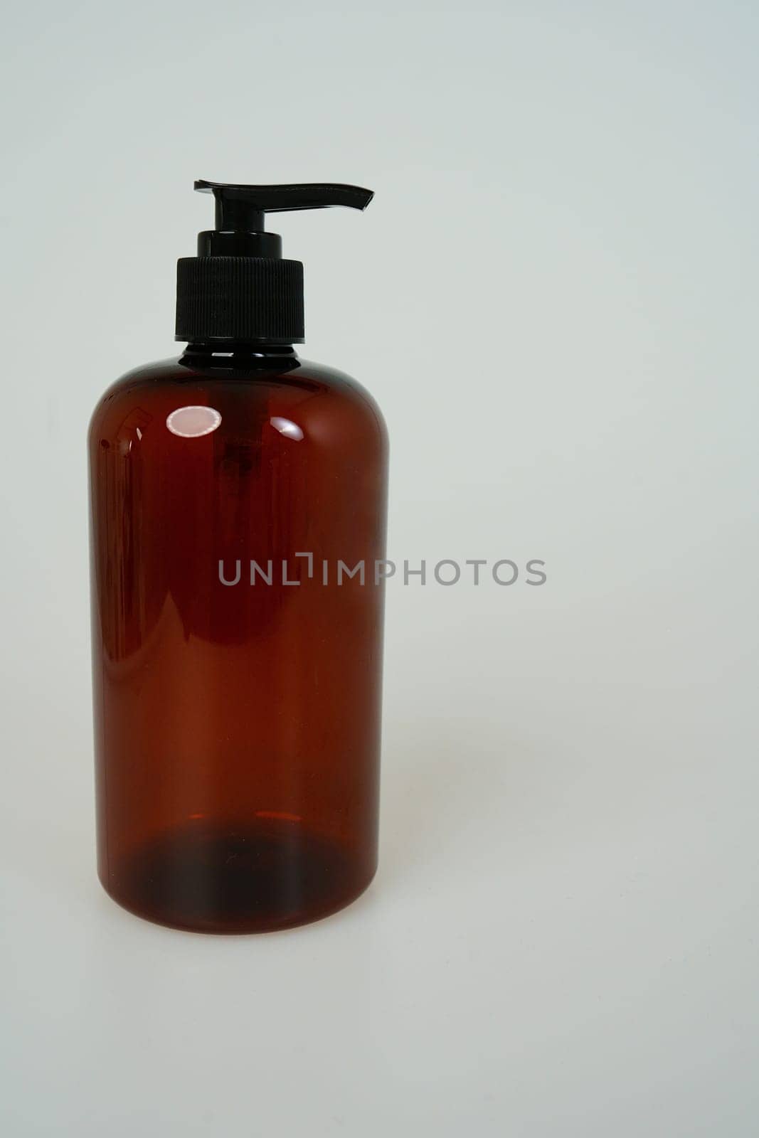 Dark shampoo or soap bottle on light background. space for text. isolated on white background. High quality photo