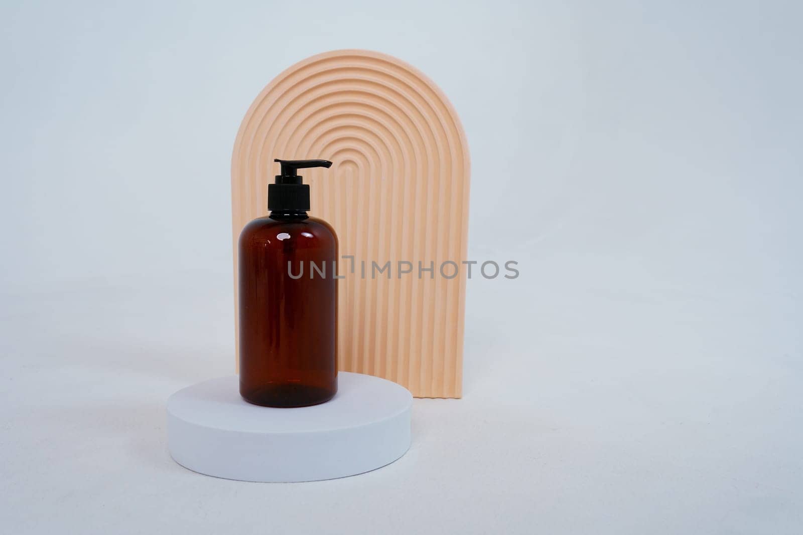 Composition with geometric shapes.body care. bottle with a dispenser, on a light gray background. Advertising concept. High quality photo