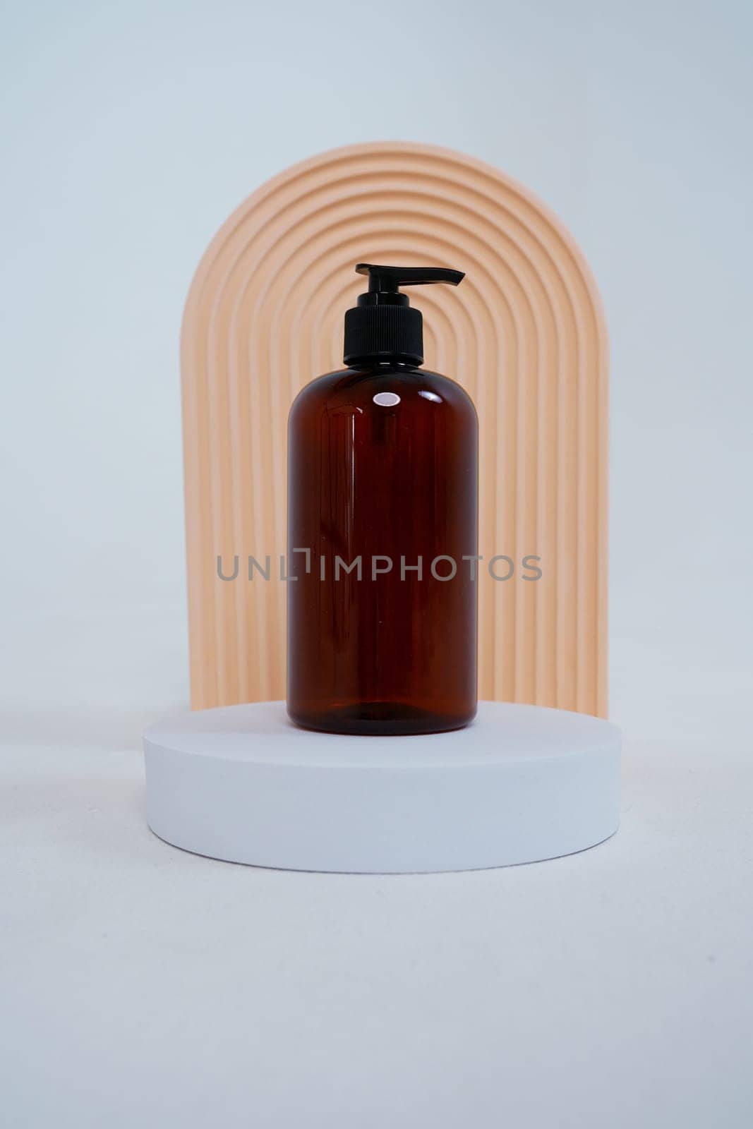 Composition with geometric shapes.body care. bottle with a dispenser, on a light gray background. Advertising concept. High quality photo