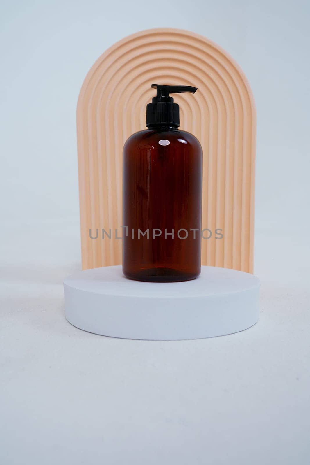 Composition with geometric shapes.body care. bottle with a dispenser, on a light gray background. Advertising concept. High quality photo