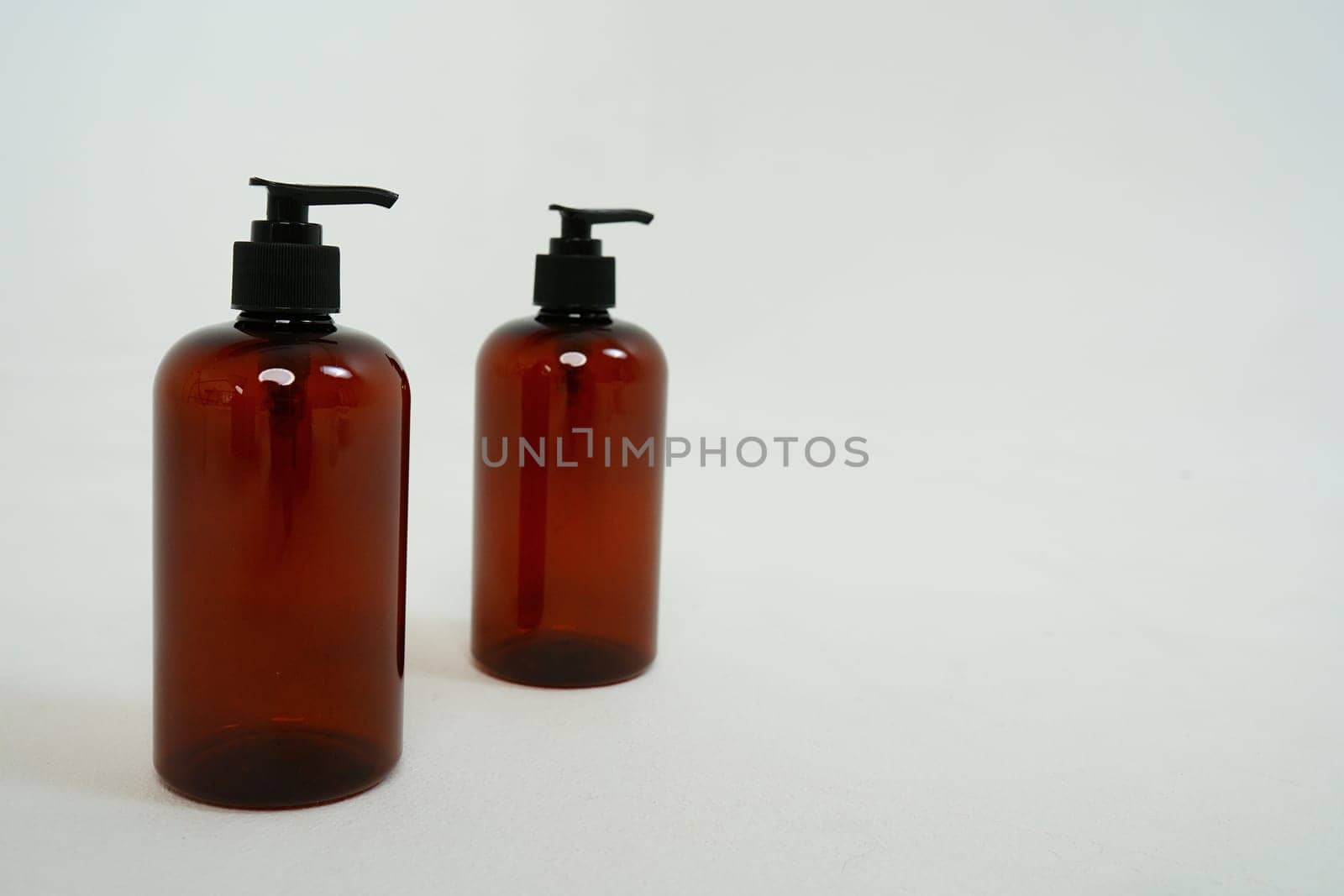 Two dark bottles with soap dispensers on a white background. isolated on white background by tewolf