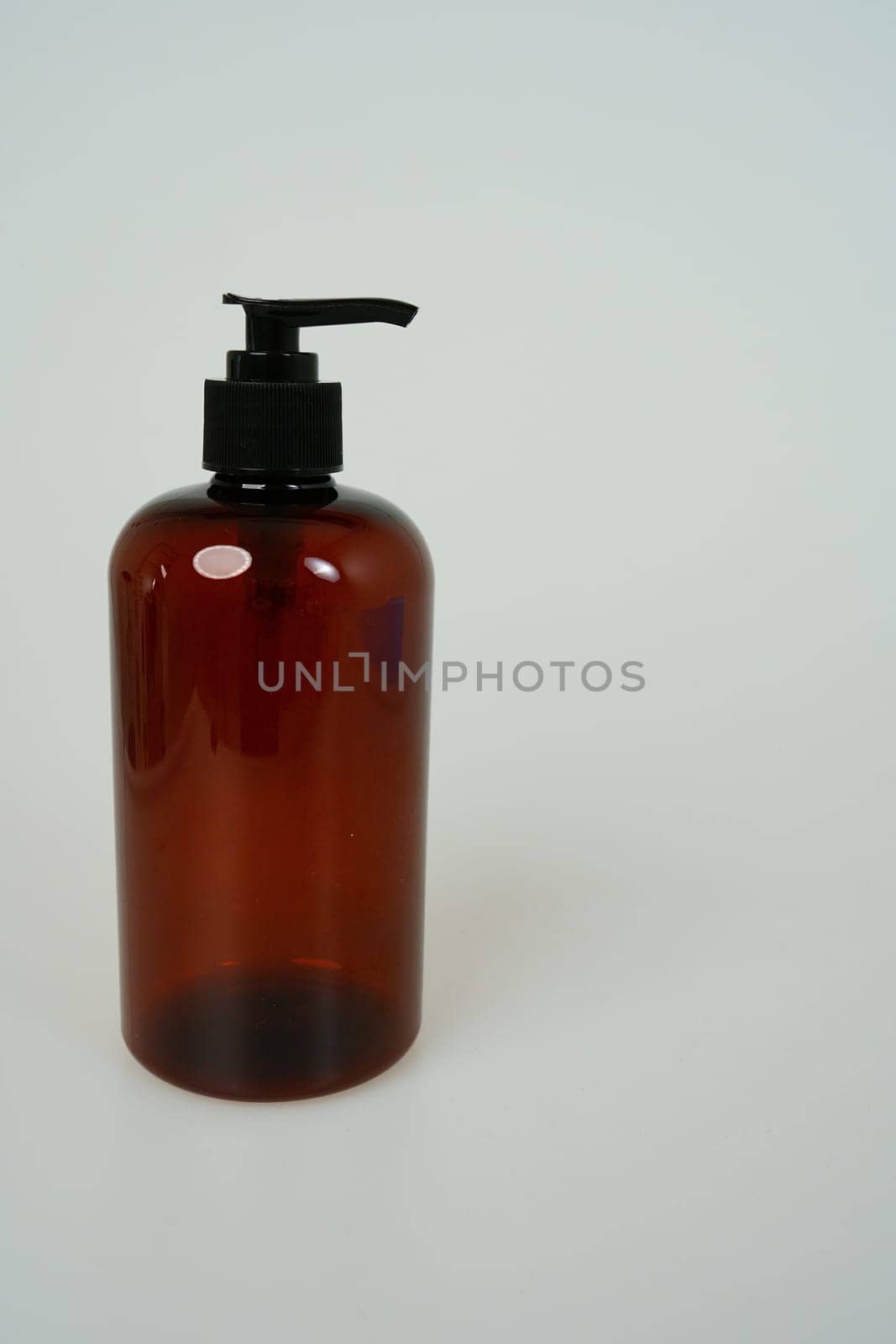 Dark shampoo or soap bottle on light background. space for text. isolated on white background by tewolf