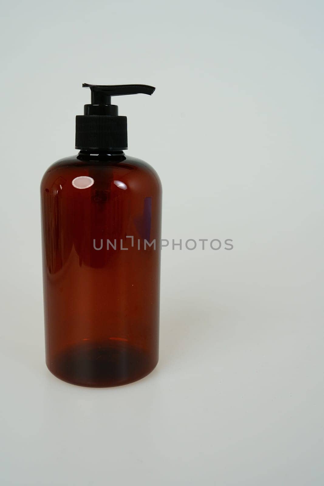 Dark shampoo or soap bottle on light background. space for text. isolated on white background by tewolf