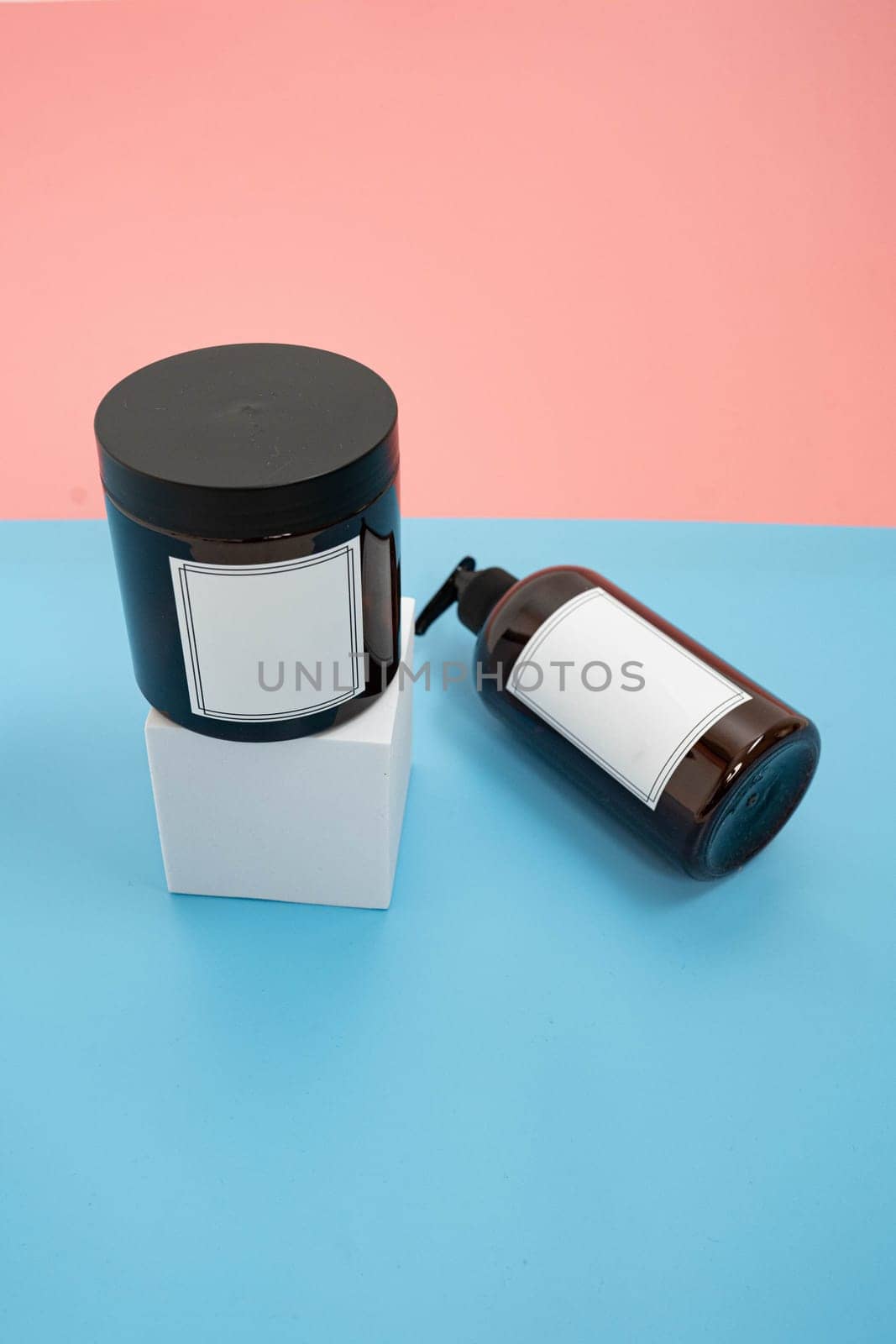 Body care. set of bottles with dispensers and jars of body cream on a blue and pink background. Advertising concept by tewolf