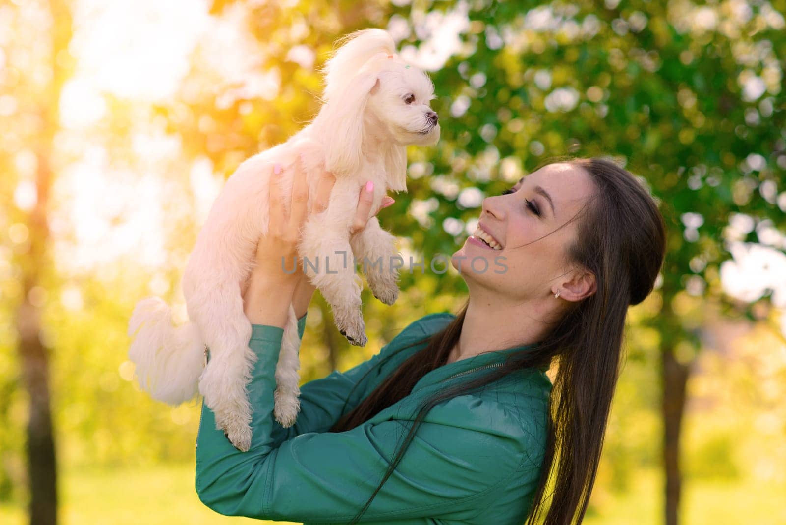 Young woman with her dog. Puppy white dog is running with it's owner. Concept about friendship and animal.