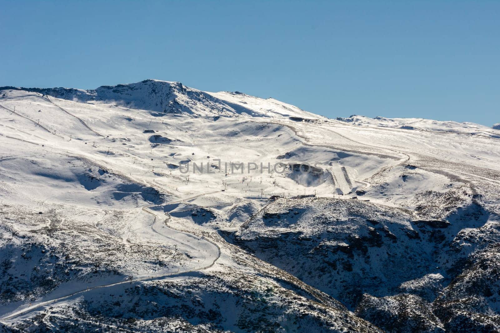 panoramic view of ski resort in sierra nevada, skiers along the slopes,