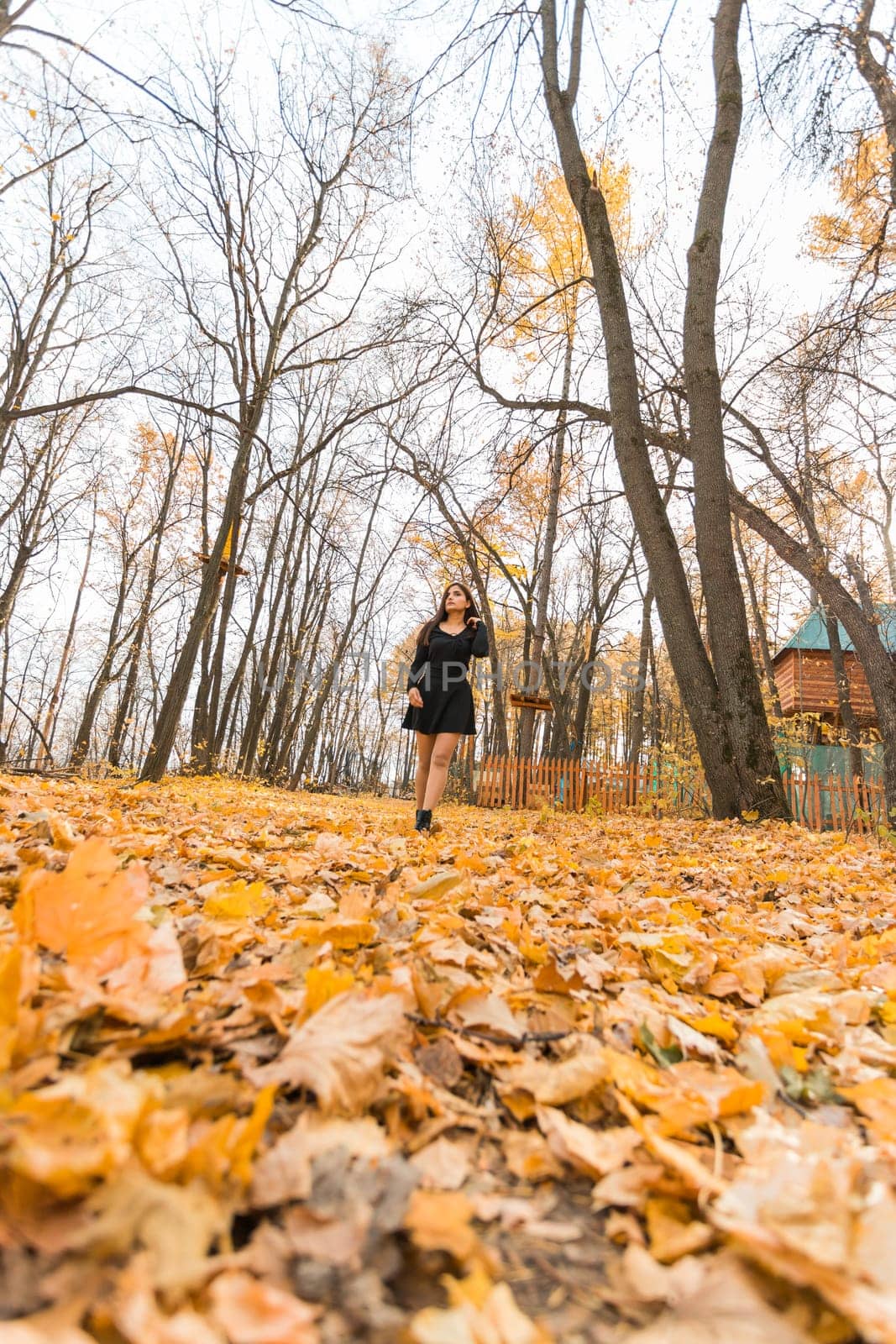 Close-up portrait of a young beautiful confident Indian Asian woman in fall outdoor. Happy and natural smiling female. Generation z and gen z youth