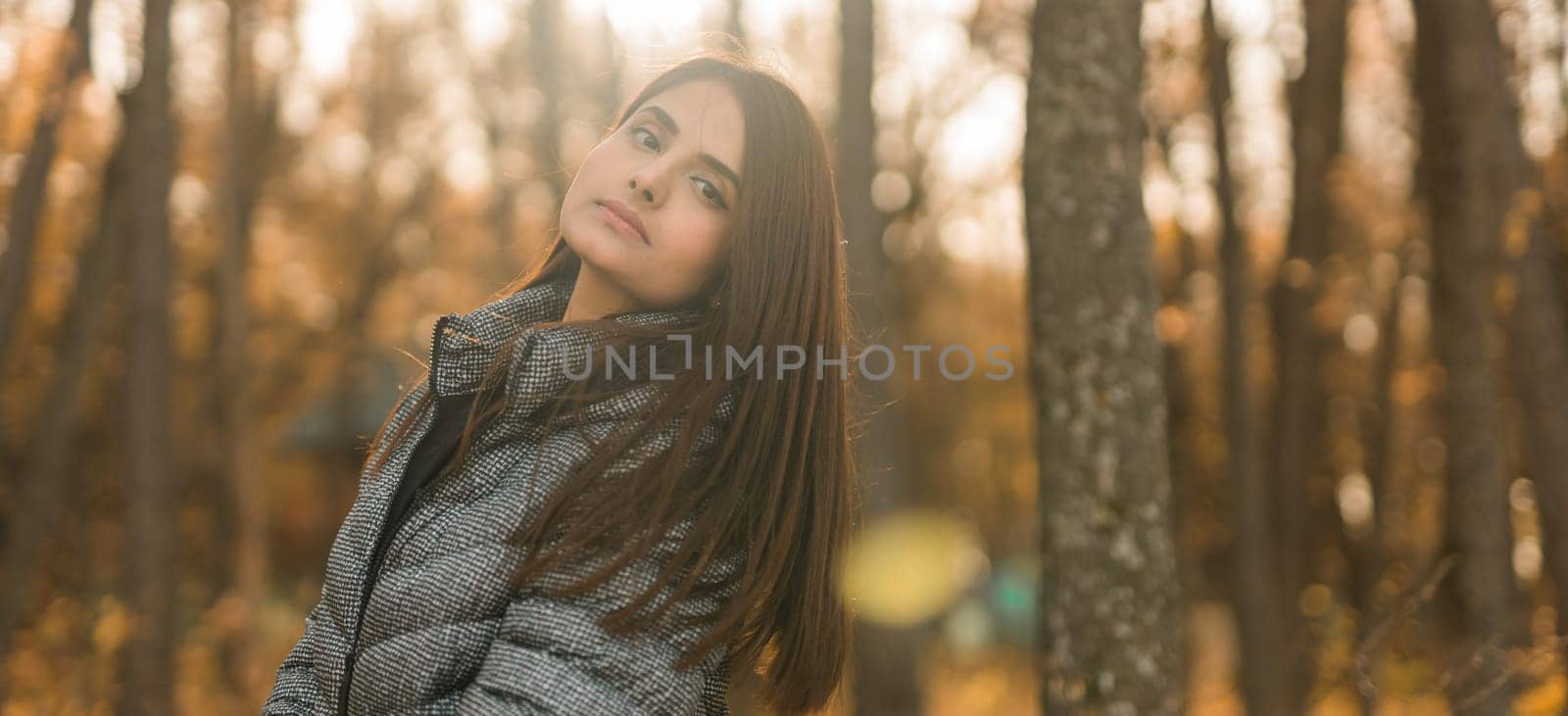 Banner beautiful indian woman generation z relaxing and feeling nature at autumn park in fall season copy space. Diversity and gen z youth by Satura86