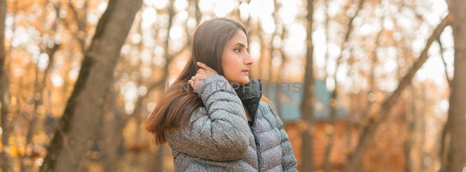 Close-up portrait of a young beautiful confident Indian Asian woman in fall outdoor. Happy and natural smiling female. Generation z and gen z youth