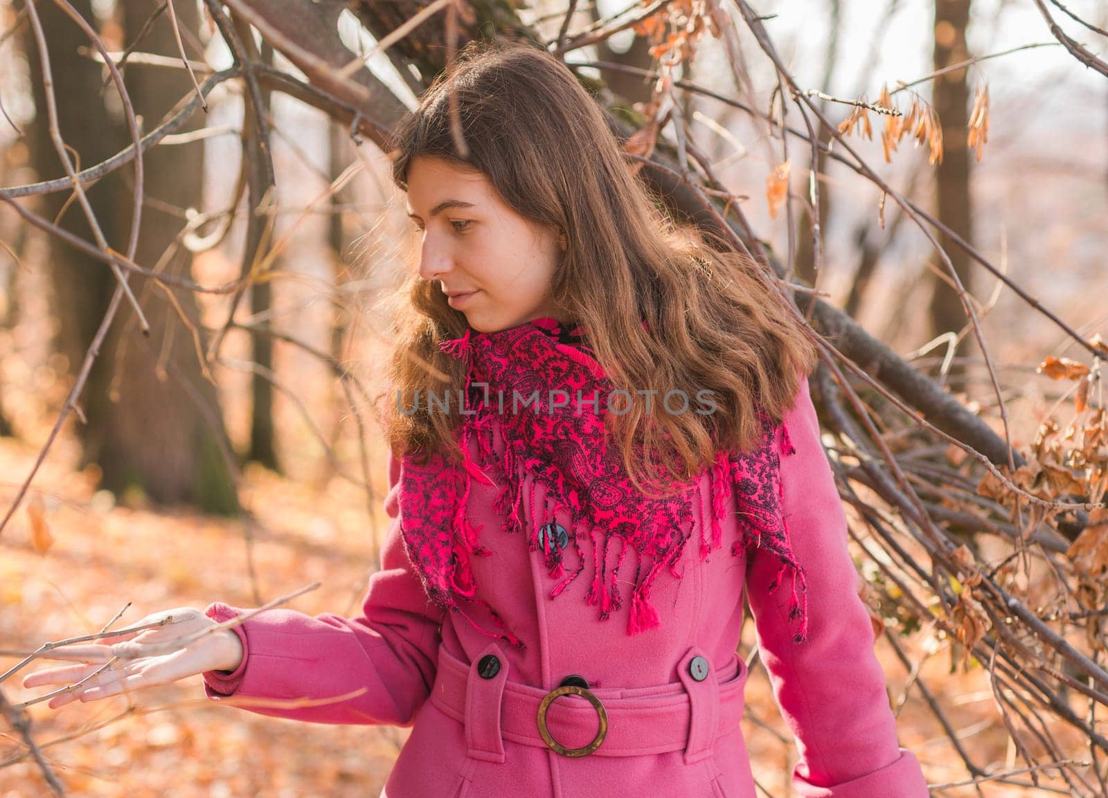 Beautiful happy smiling girl with long hair wearing black hat and pink jacket posing in autumn park. Outdoor portrait day light. Autumn mood concept. Copy empty space for text.