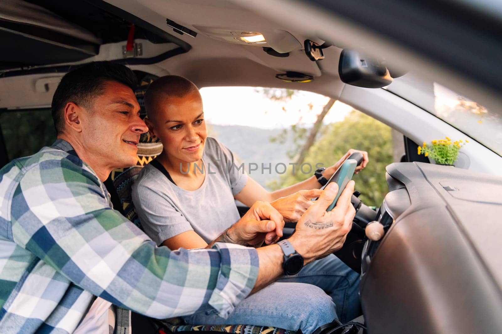 couple planning on phone the route in camper van by raulmelldo