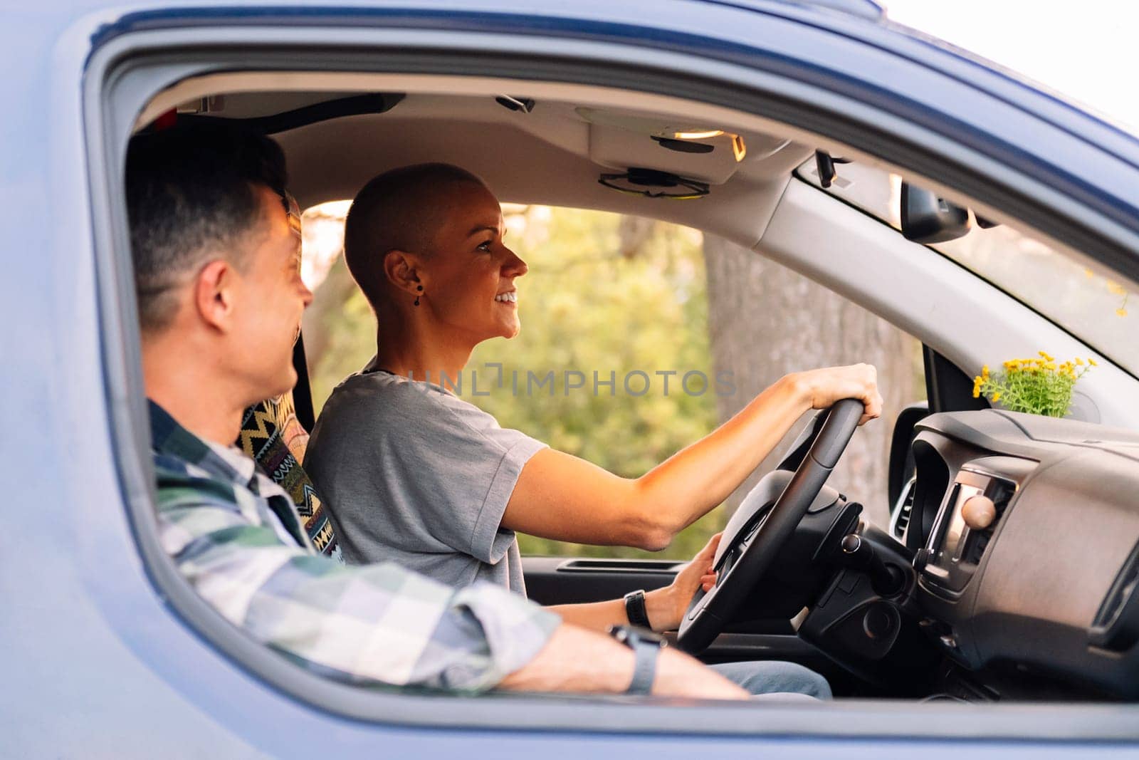 happy couple driving their camper van during a road trip through the countryside, concept of adventure travel and active tourism in nature