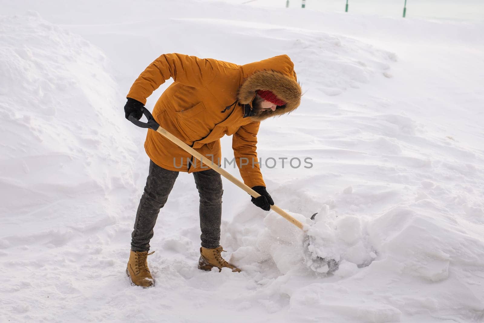 Man removing snow and ice from the sidewalk in front of house. Winter season by Satura86