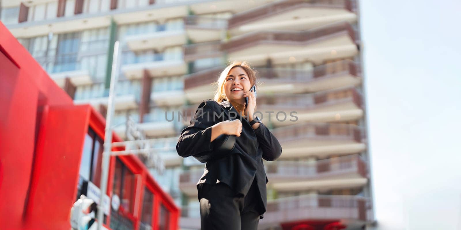 Successful business woman talking on mobile outdoor. beautiful woman going to working with smartphone walking near office building.