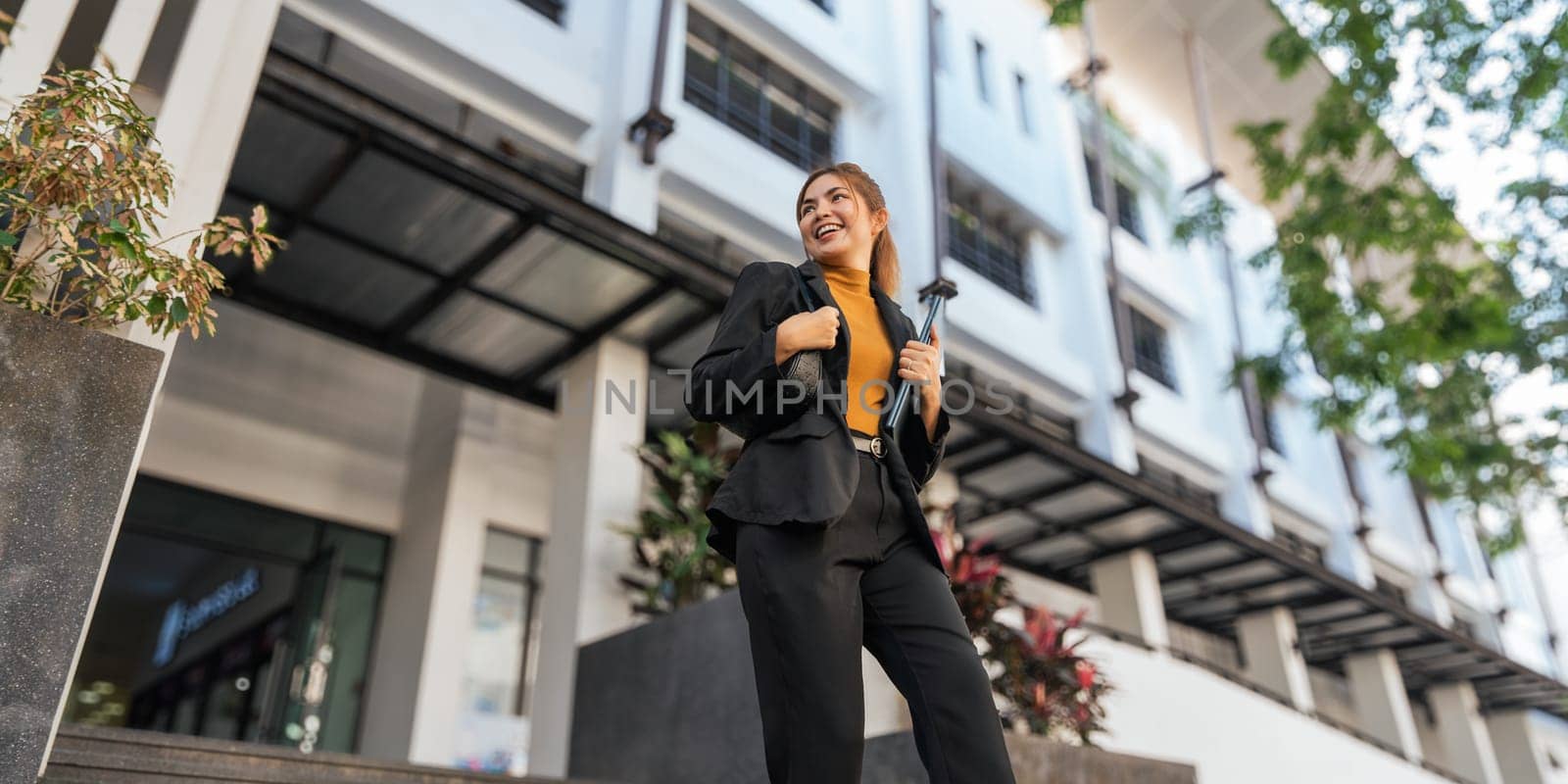 Business woman successful walking outdoors to work. beautiful woman going to working with coffee walking near office building by nateemee