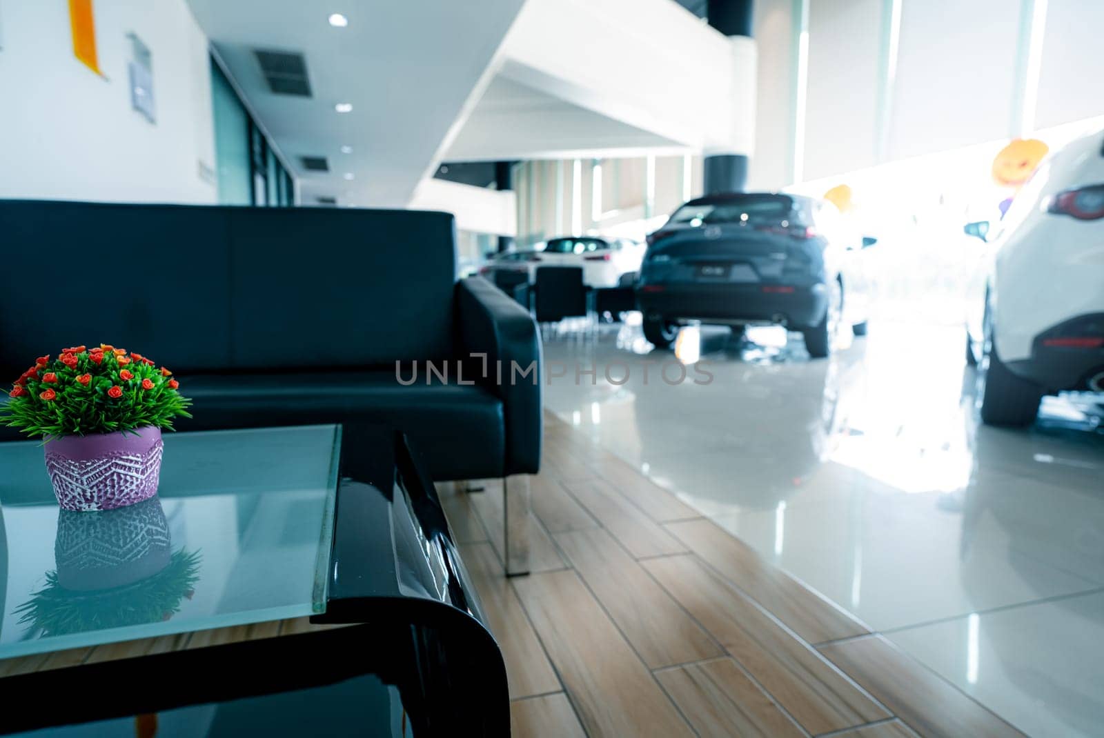 Blurred car parked in luxury showroom.  Car dealership office. New car parked in modern showroom. Automobile leasing and insurance background. Auto leasing business. Electric vehicle. Reception area.