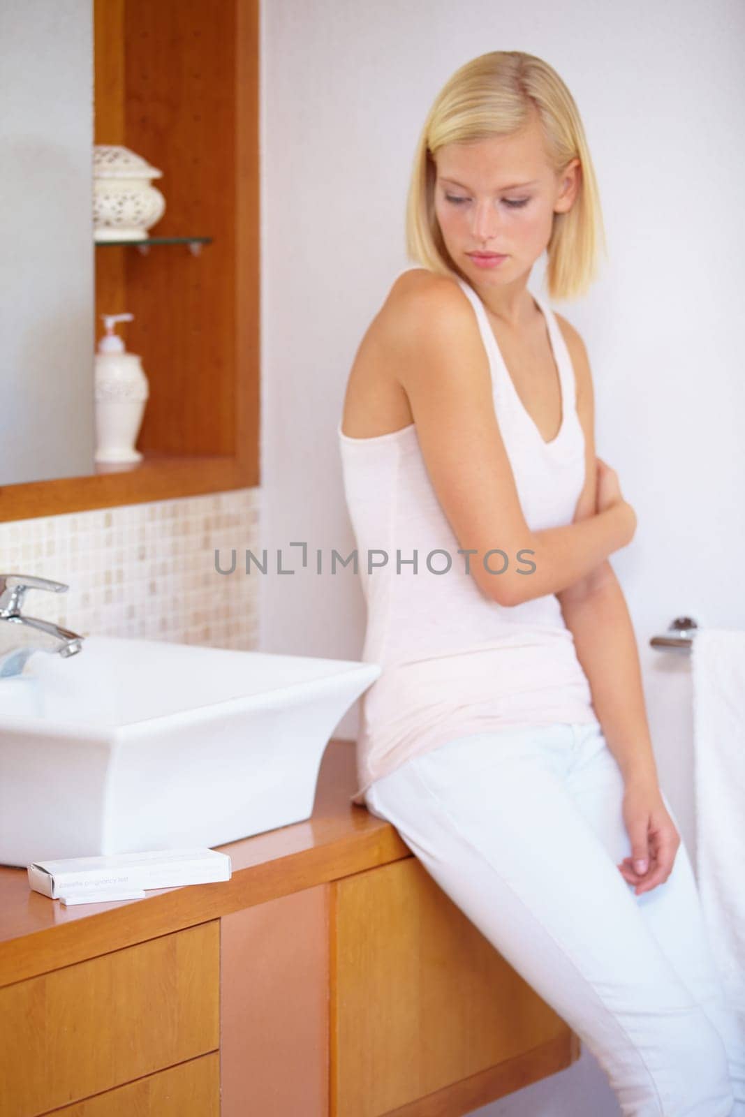 Worry, anxiety and woman with pregnancy test in bathroom waiting for results, news and information. Motherhood, pregnant and sad person with medical testing kit for fertility or ovulation at home.