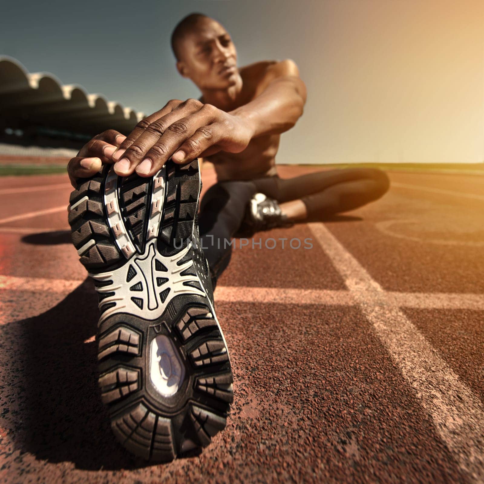 Man, face and stretching leg on ground, outdoors and fitness for health, sports and performance. Black male person, athlete and warmup on track, workout and commitment or ready, train and cardio by YuriArcurs