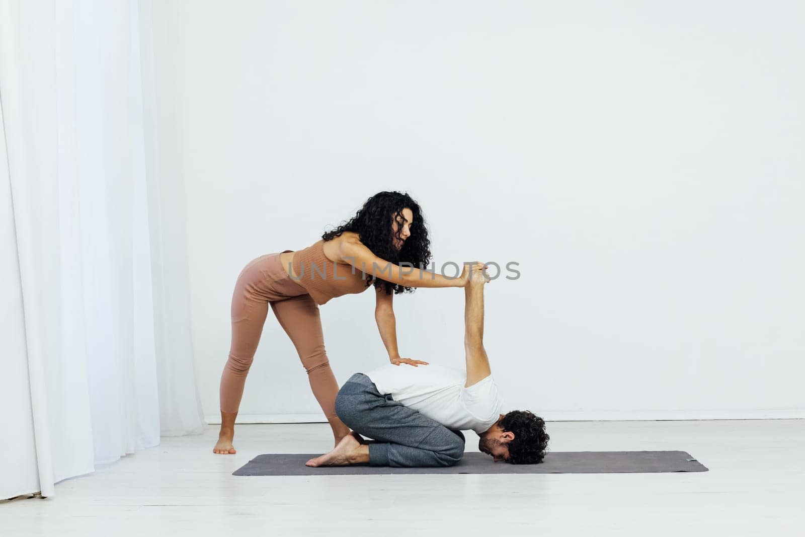 Man and woman doing yoga exercises meditation asana lotus pose by Simakov