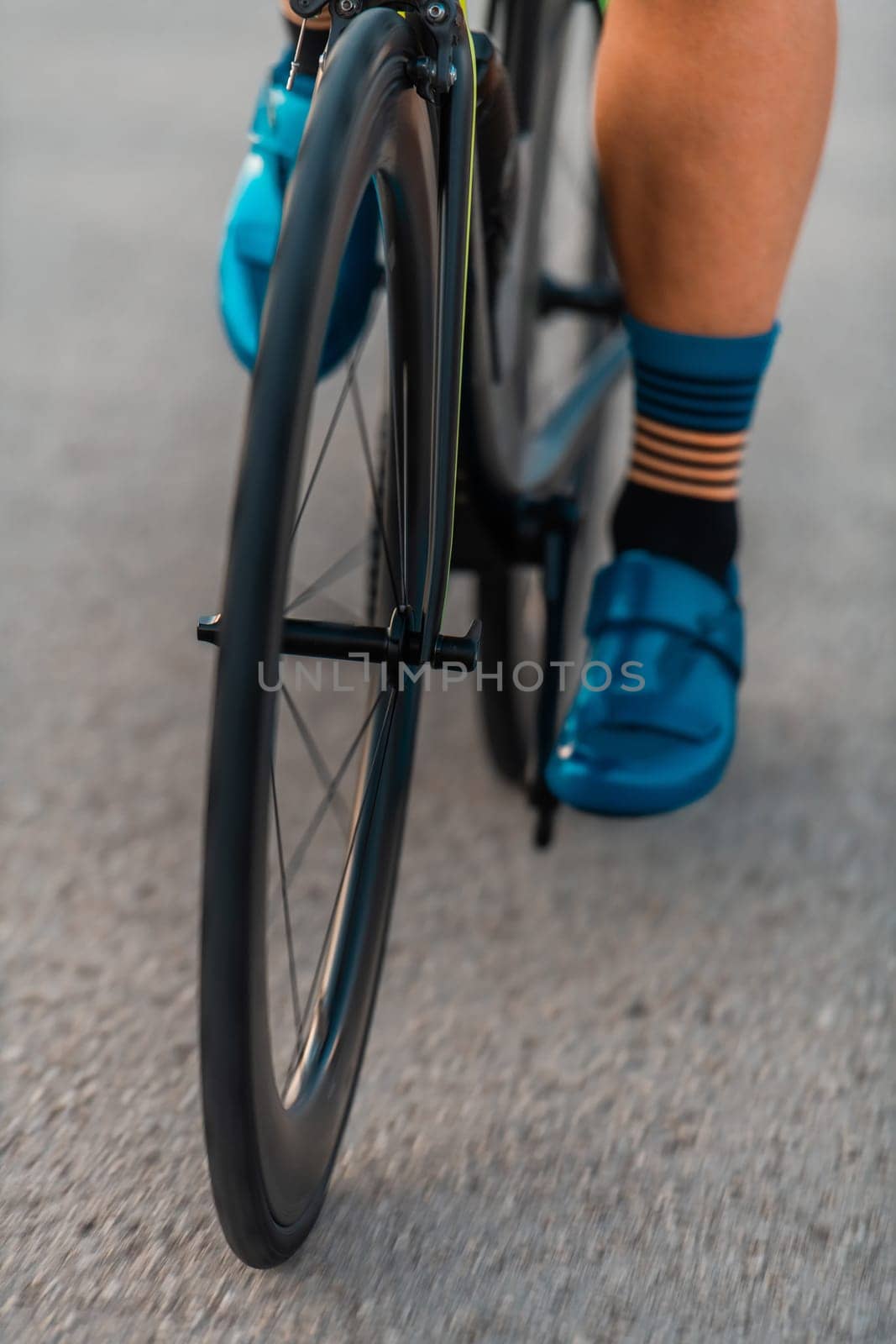 Close up of the pedals of a bicycle being ridden by a professional triathlete preparing for training.