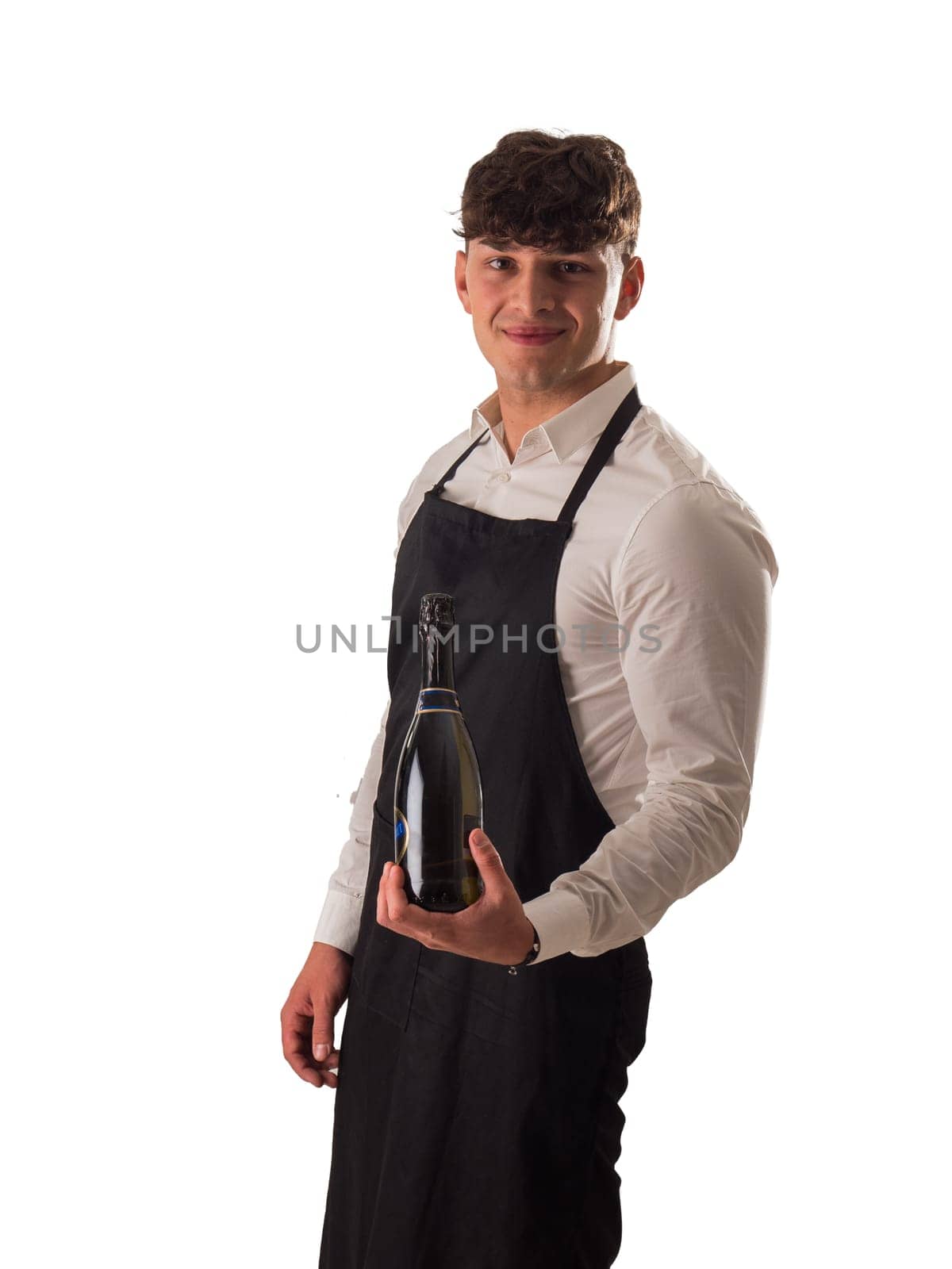 A man in an apron holding a bottle of wine