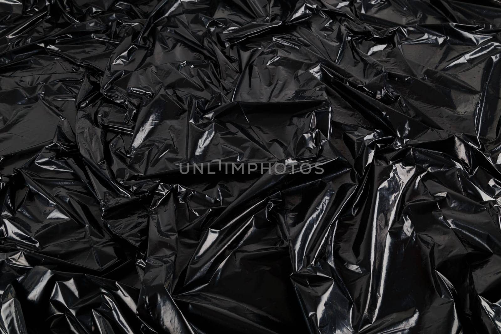 full frame abstract background of crumpled black plastic film bag by z1b