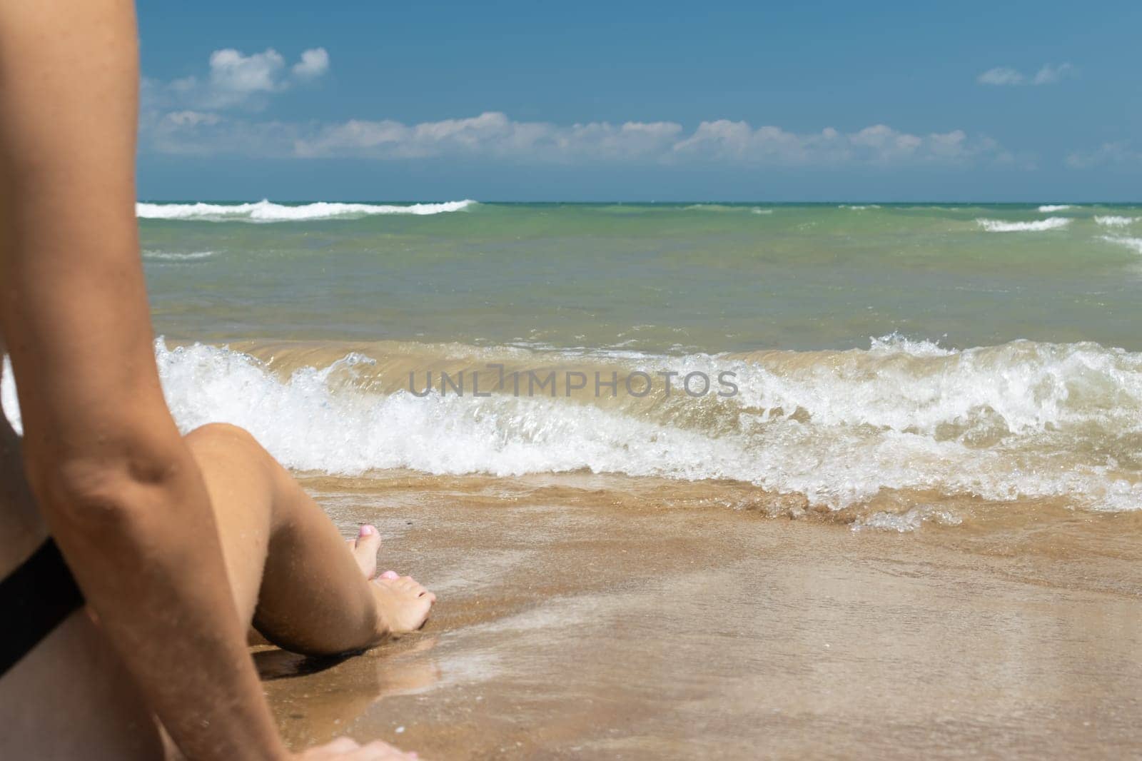 girl on the beach near the sea, close up on the girl arm and leg with a place for an inscription. High quality photo