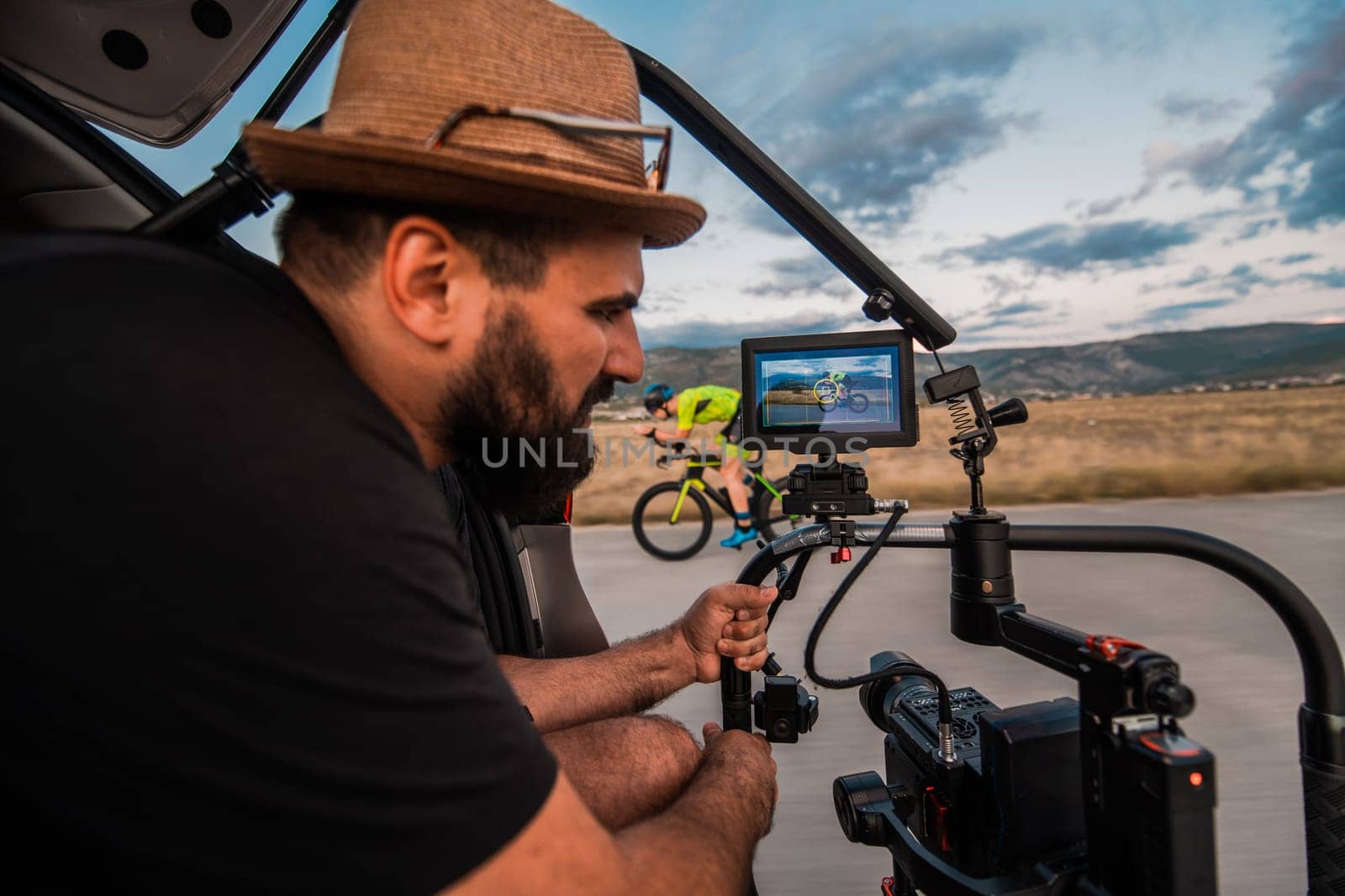 A videographer recording a triathlete riding his bike preparing for an upcoming marathon.Athlete's physical endurance and the dedication required to succeed in the sport. by dotshock