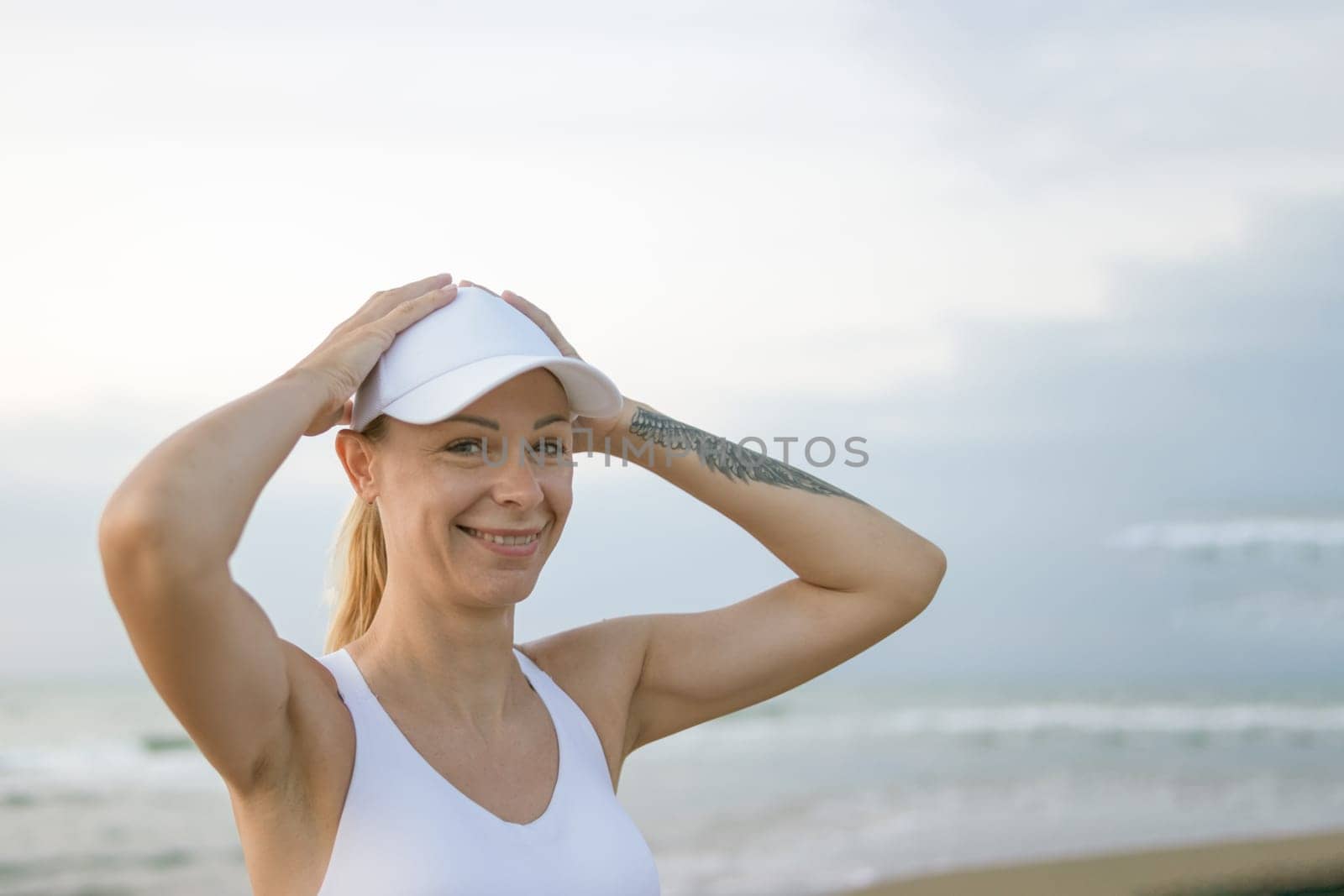 a portrait of a fair-looking girl in a white top and top stands against the backdrop of the sea, there is a place for an inscription. High quality photo