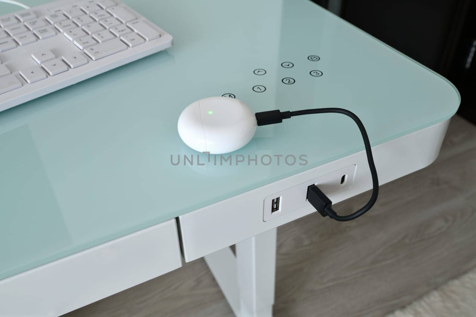 Box for wireless headphones is charged from USB table