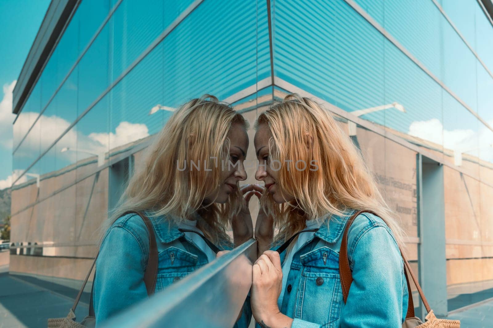 Portrait of a young woman in a denim jacket looking at a store window. High quality photo